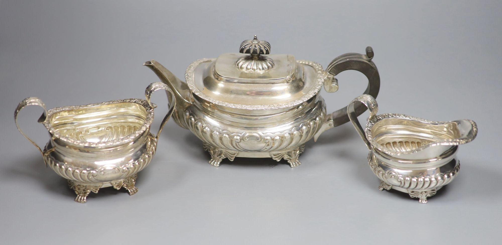 A late Victorian demi fluted silver three piece tea set, Charles Stuart Harris, London, 1899, gross 25.5oz (a.f.).